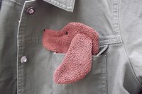 Smudge Dog peeking out of a pocket of a jean jacket.