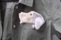 Smudge Dog peeking out of a pocket of a jean jacket.