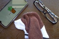 Smudge Dog shown with phone and glasses. Two of the items it can clean.