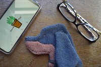 Smudge Dog with glasses and smart phone, two of the items it can clean.