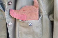 Smudge Dog peeking out of the pocket of a jean jacket.