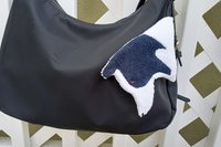Border Collie Smudge dog with collar looped on handbag.