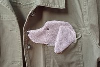 Smudge dog peeking out of the pocket of a jean jacket