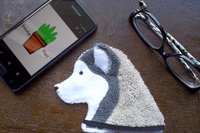 Smudge Dog shown with phone and glasses. Two of the items it can clean.