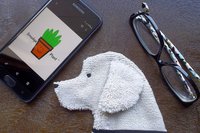 Smudge Dog shown with phone and glasses. Two of the items it can clean.