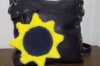 Sunflower attached to black purse.