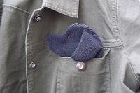 Smudge Dog peeking out of the pocket of a jean jacket.