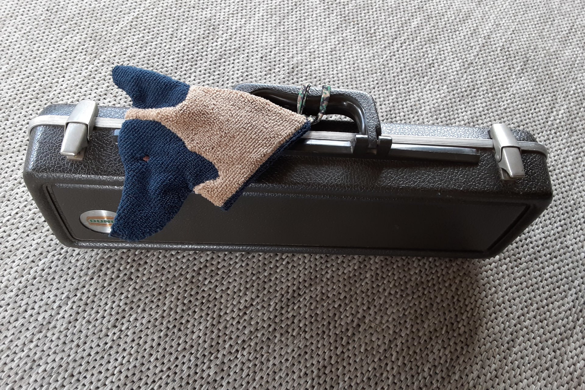 Smudge Dog attached to a musical instrument case. Handy for cleaning.