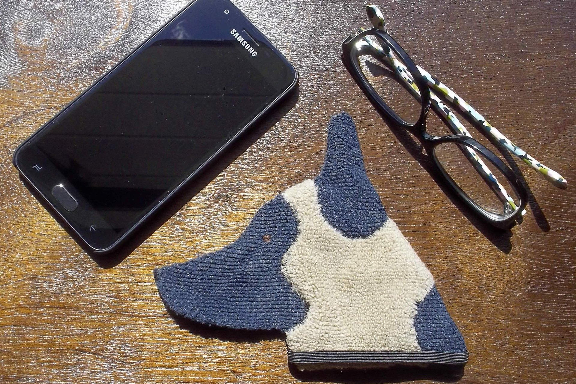 Smudge Dog with smart phone and glasses.