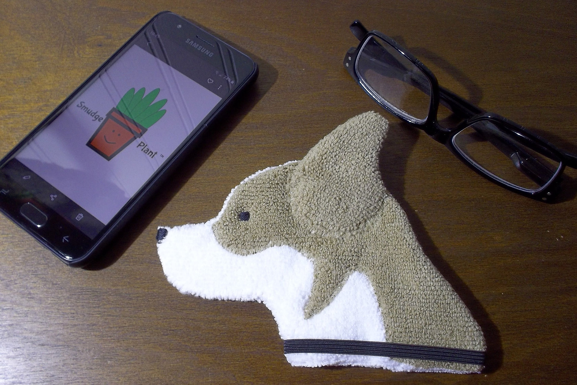 Smudge Dog with smart phone and glasses.