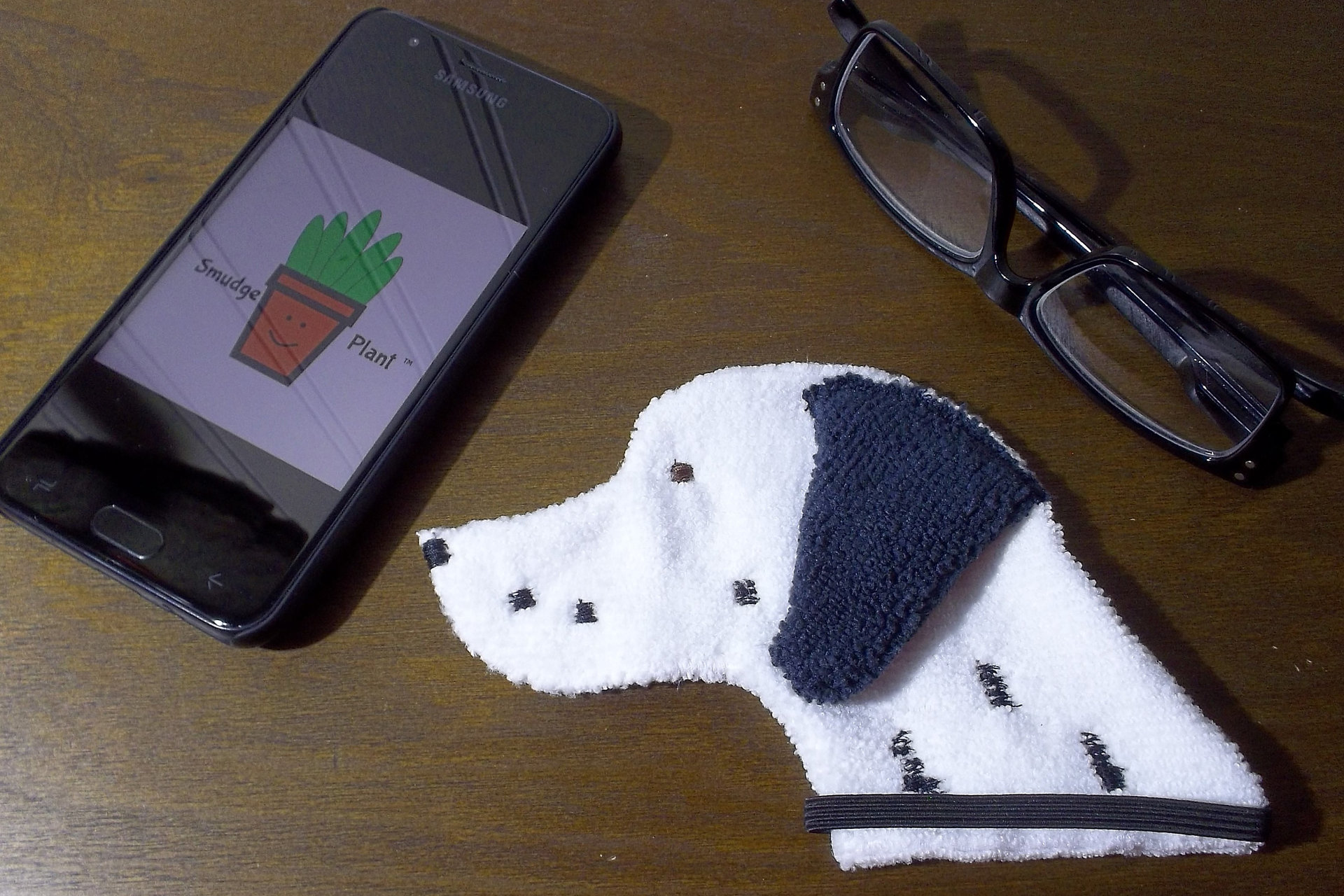 Smudge Dog with smart phone and glasses.