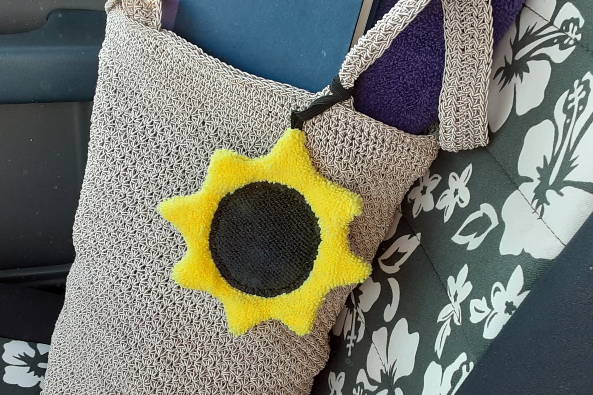 Sunflower on beach bag on car seat.