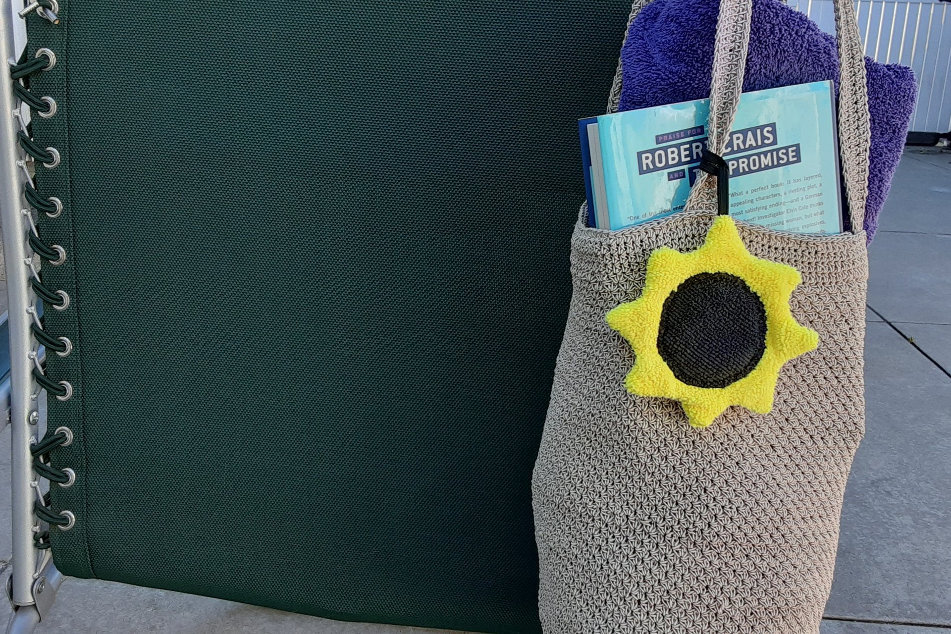 Sunflower attached to beach bag on beach chair.