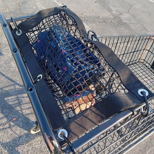Purse and All Safety Net attached to shopping cart to protect items in child carrier section of cart